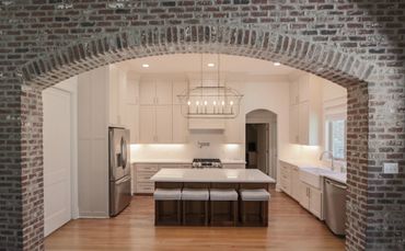 Modern kitchen with brick archway and island seating.