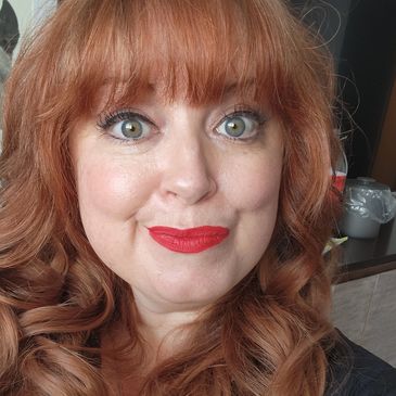 Woman with red hair and red lipstick ready for a girls night celebration.