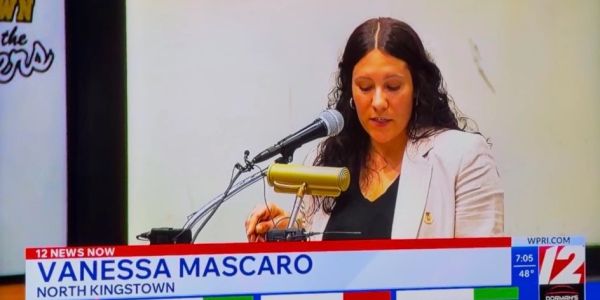 Vanessa Mascaro speaking at a podium during a news segment.