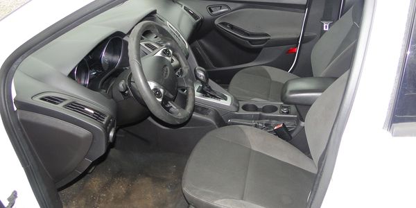 Interior of a car showing front seats and dashboard with steering wheel.
