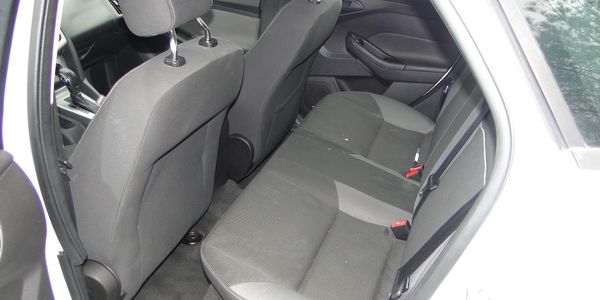 Interior view of a car's rear seats with grey upholstery.