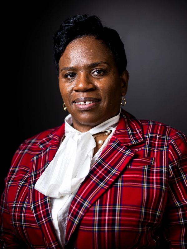 Portrait of a woman in a red plaid blazer.