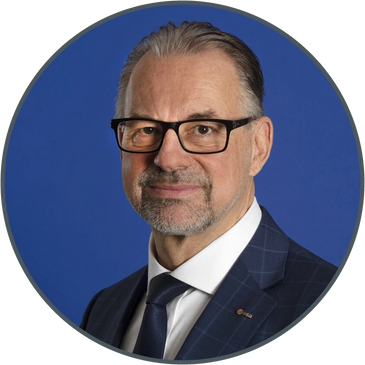 Professional man wearing glasses and a suit against a blue background.