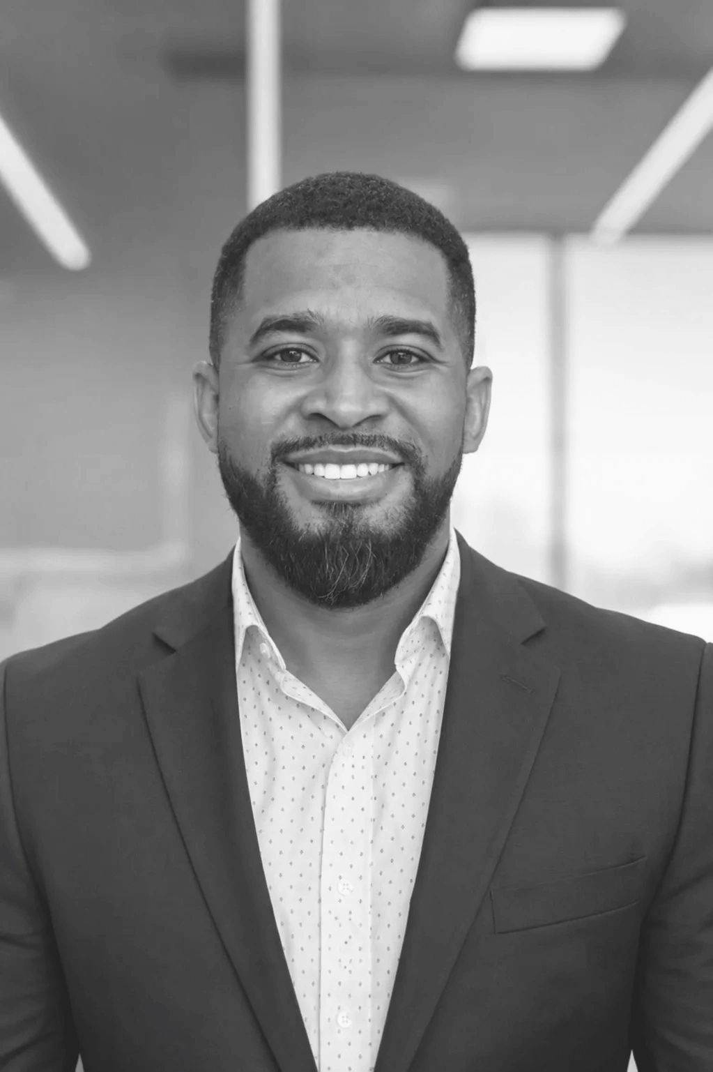 Smiling man in a suit and dress shirt.