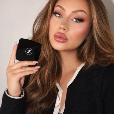 Woman holding a Chanel makeup compact with glamorous makeup.