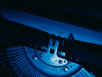 antique typewriter showing typed coming soon words on paper