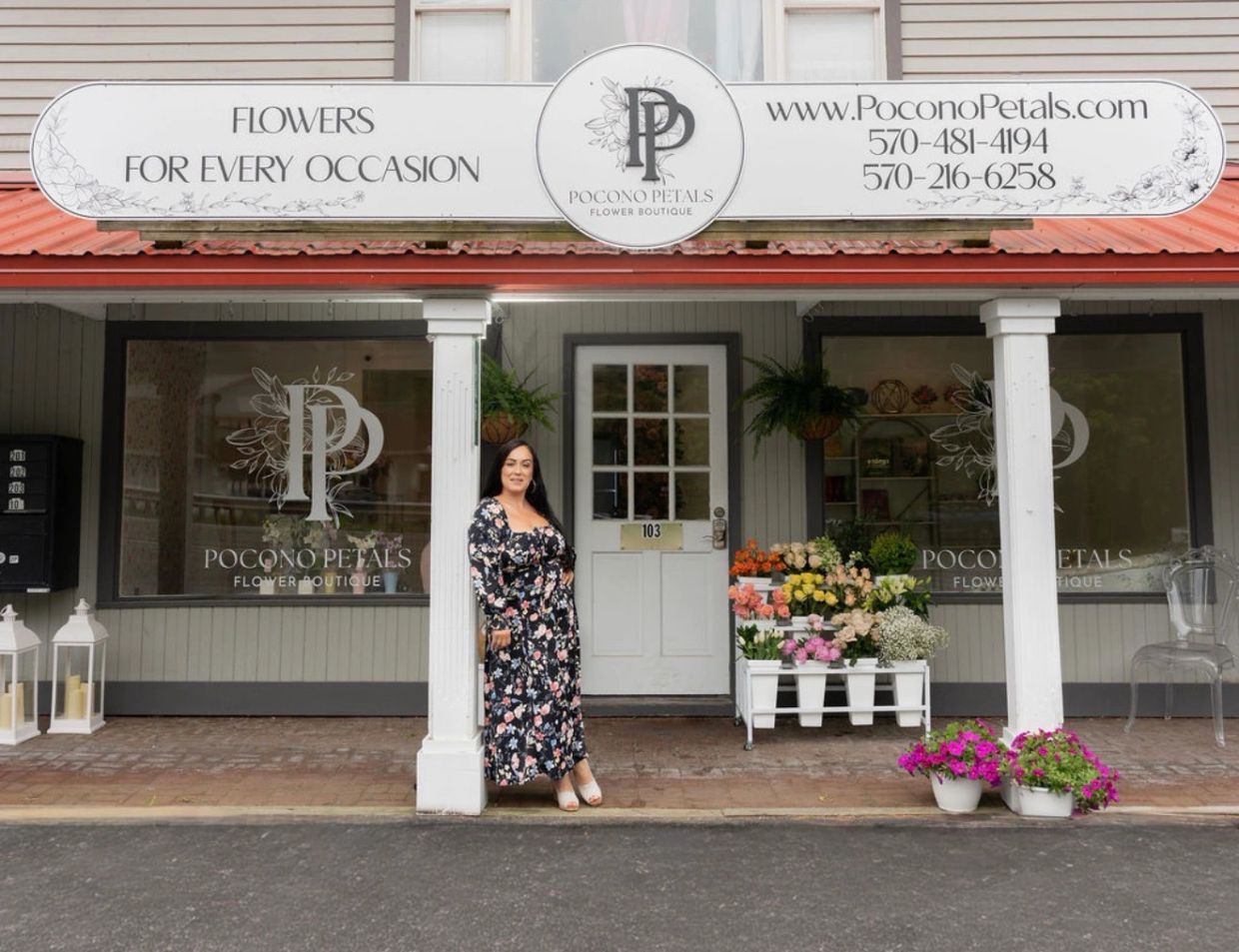 Woman posing outside a flower boutique called Pocono Petals.