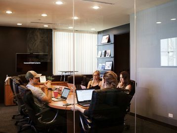 Four people having a meeting in a modern office conference room.