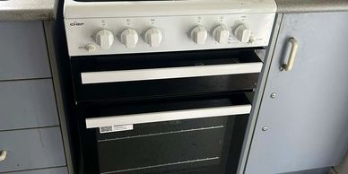 A white gas stove with four burners in a kitchen.