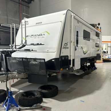 Jayco Expanda Outback caravan in a workshop with removed wheels.