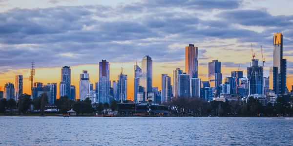 City skyline during sunset with water in the foreground.