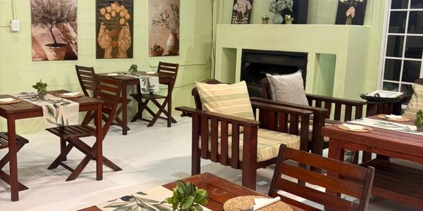 Cozy dining area with wooden furniture and floral decorations.