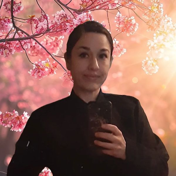 Person taking a selfie with a cherry blossom background.