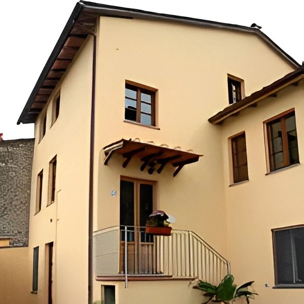 
Light yellow building with balcony and awning.