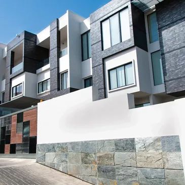 Modern residential building with stone and white facade.