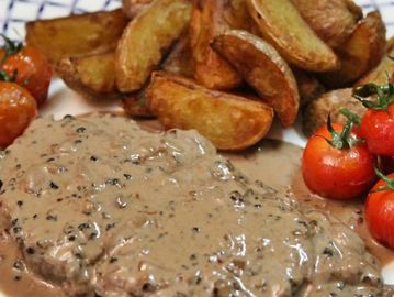 Steak sauce aux champignons avec pommes de terre rôties et tomates cerises.