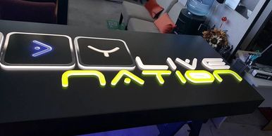 Illuminated sign spelling 'WAY NATION' in modern style on a black surface.