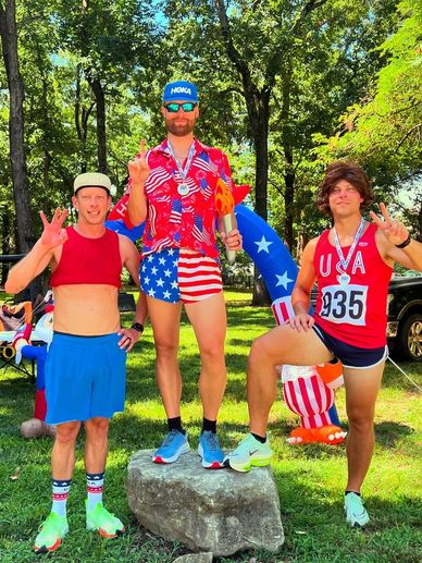 Three men in patriotic outfits posing outdoors in summer.
