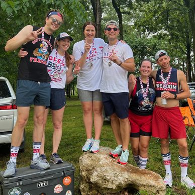 Group of friends celebrating with medals outdoors.