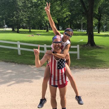 Man piggybacking young girl, both cheering.