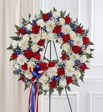Red, white, and blue floral wreath with a ribbon.