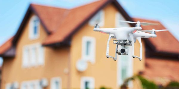 Drone surveying a house