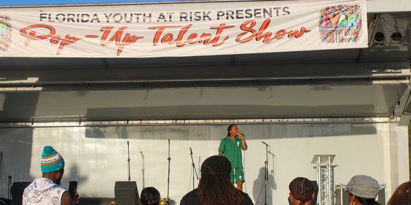 Florida Youth at Risk “Pop-Up Talent Show” on covered mobile stage at a South Florida event

