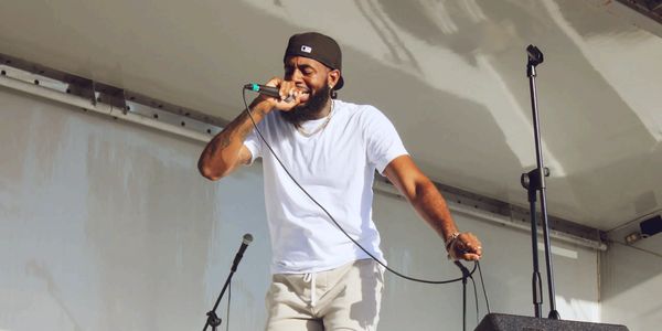 Performer with handheld mic on covered mobile stage at South Florida youth event