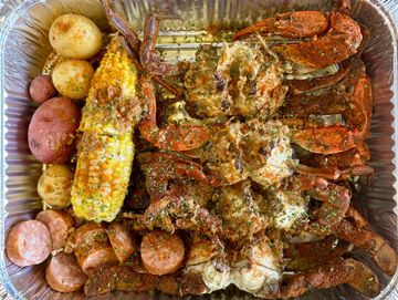 Seafood boil with crab, corn, potatoes, and sausage.