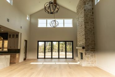 Spacious living room with high ceilings and large windows.