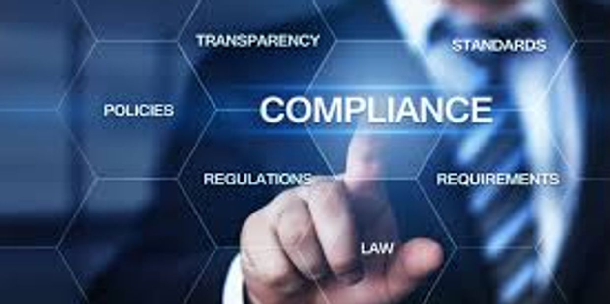 Businessman pointing at compliance concepts on a digital interface.