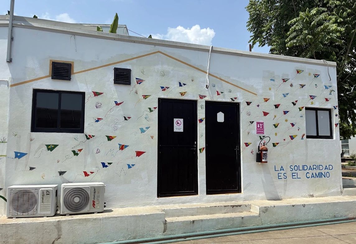 A mural outside the UNICEF-funded Solidarity and Hospitality Shelter represents people who have stayed at the shelter with paper planes featuring the flags of their countries. The text on the bottom right reads: “Solidarity is the way.” 
