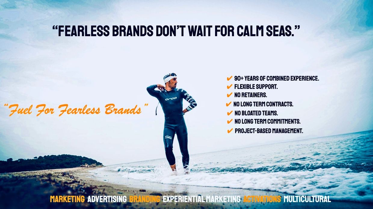 A confident swimmer stands at the ocean's edge with a bold marketing message about fearless brands.