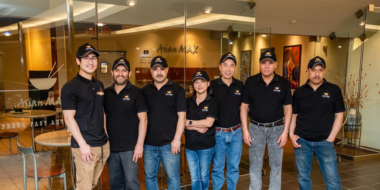 Group of people wearing Asian Max black shirt uniform and caps