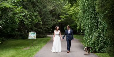 A photograph of a bride and a groom walking down a country lane.