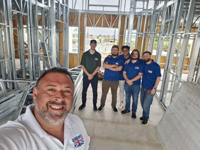 Group selfie at a construction site with metal framing.