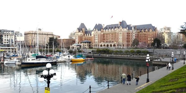 Boats docked at a harbor in front of a large historic building.