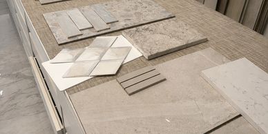 Various beige and cream tile samples laid out on a countertop.