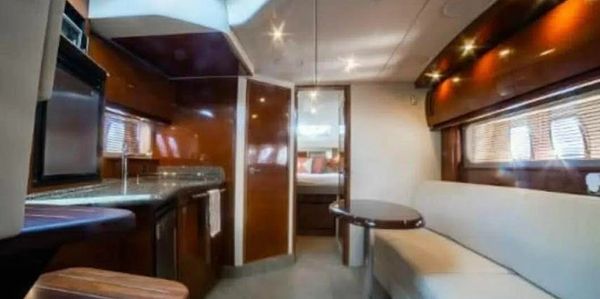 Interior of a modern yacht with seating and kitchen area.