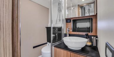 Modern compact bathroom with vessel sink and wood accents.