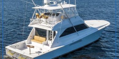 A white fishing yacht on calm blue water.