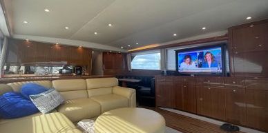 Luxurious yacht interior with comfortable seating and a TV.