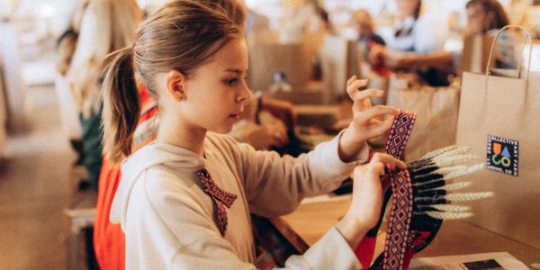 Young girl crafting a decorative item with focused attention.