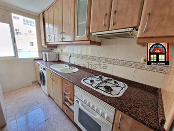 Cocina con muebles de madera y electrodomésticos.