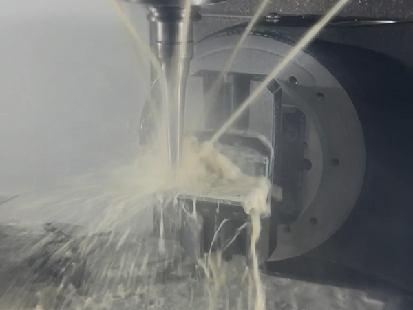 CNC machine cutting metal with coolant spray for precision.