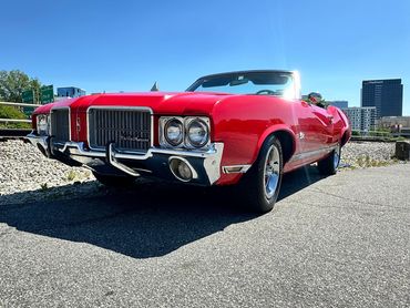 A classic red convertible car parked on a sunny day.