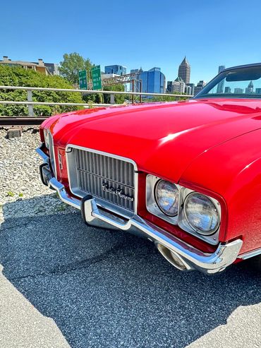 Front view of a red classic Oldsmobile car.