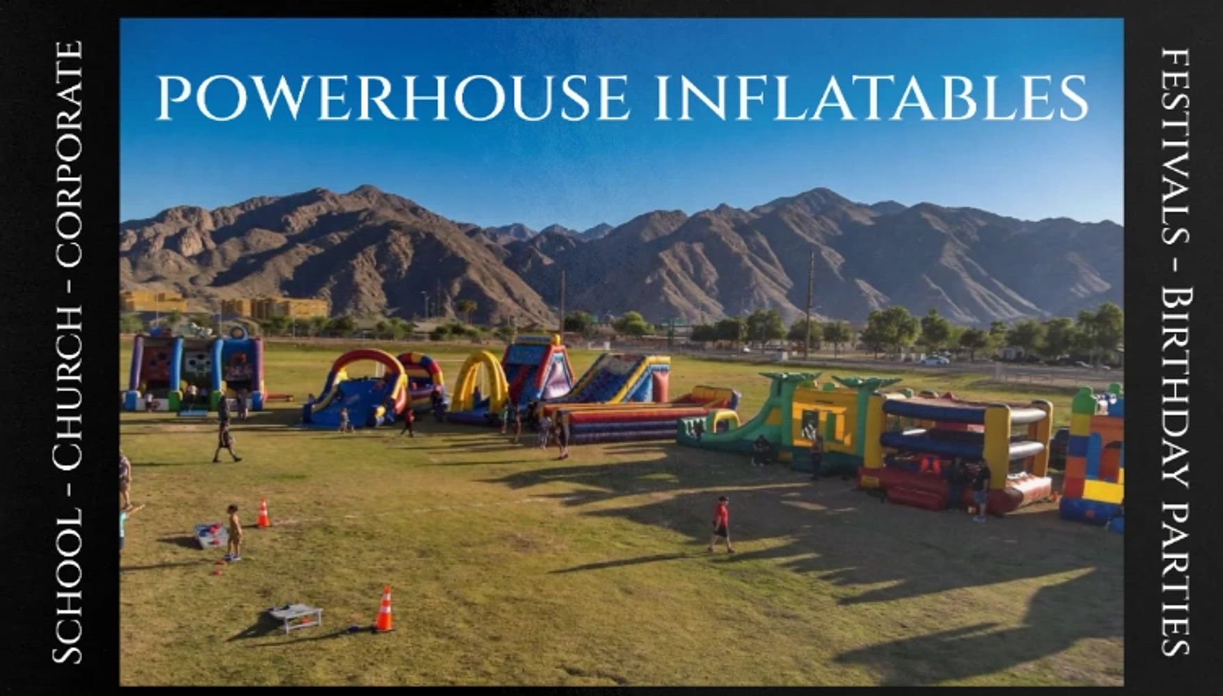 Outdoor event with various inflatable play structures and mountains in the background.