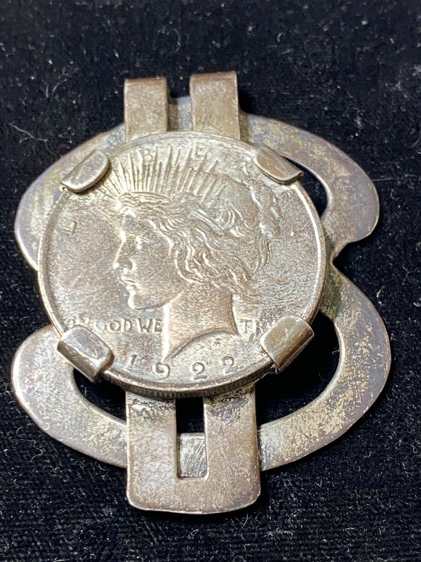 Vintage 1922 coin brooch with intricate metal design.