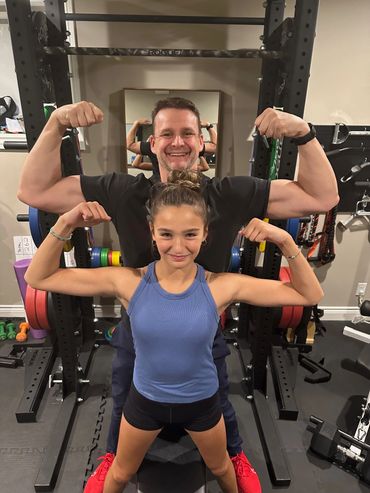 Marc and his daughter Zoey, one half of the twins, working out in the home gym